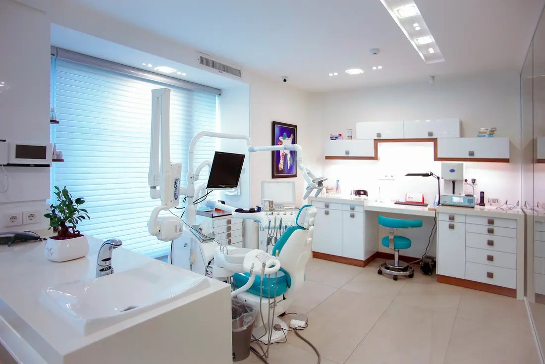 Modern dental treatment room with chair, monitor and natural light