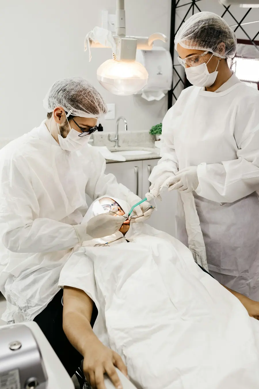 Dentist and assistant treating a patient in a clinic